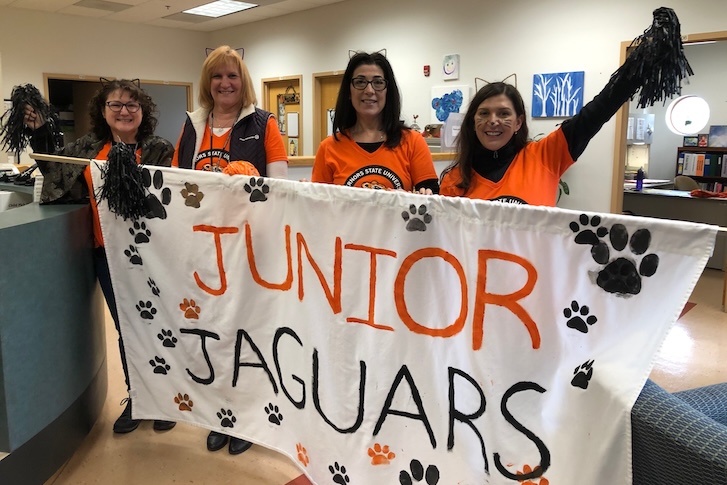 FDC staff members holding up Junior Jaguars sign